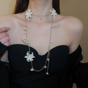 Close-up of pearl flower waist chain with silver links and white acrylic floral accents