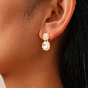Détail d'une boucle d'oreille en or avec pavé de diamants et grand pendentif cristal