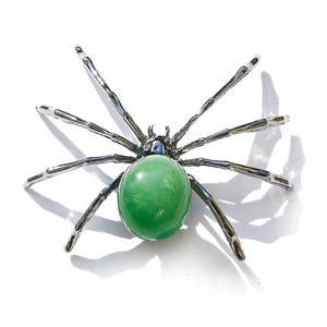 Detailed close-up of a spider decorative ornament featuring a large green gemstone body