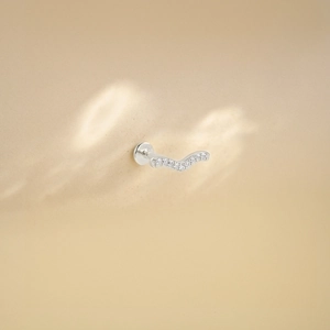 Detailed close-up of a silver wavy cartilage stud with glistening inlaid gemstones