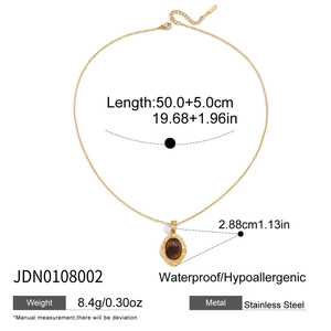 Macro detail of 18K gold-plated oval tiger eye pendant necklace in stainless steel