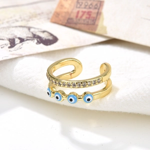 Macro shot of double-layer gold open ring with zircons and enamel evil eye details