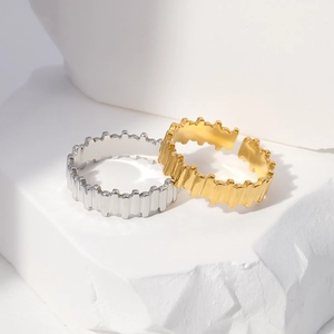 Detail of gold and silver geometric jagged open rings on minimalist stone display
