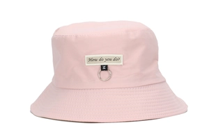 Close-up of pink bucket hat with embroidered patch and decorative metal ring detail