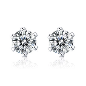 Macro shot of silver stud earrings featuring six-prong set round cubic zirconia and reflections