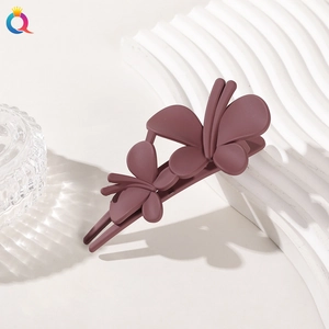 Detail of a matte mauve double butterfly hair clip with professional duckbill design