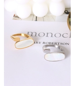 Detailed macro view of 18k gold and silver oval rings with white mother-of-pearl inlay