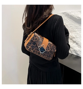 Detail of leopard print crossbody bag featuring a classic square metal buckle and leather strap