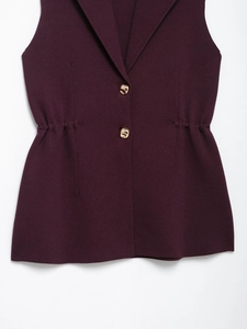 Close-up of deep burgundy knit vest featuring suit collar and gold metal buttons