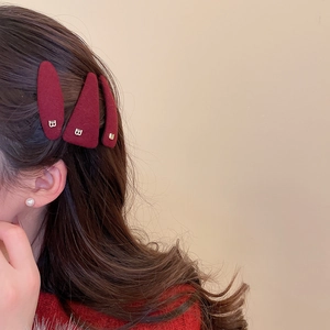 Detail view of retro wine red plush hair clips with gold letters on a model side hair