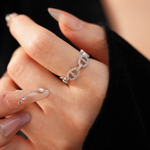 Macro shot of gold-plated pig nose ring with pavé-set cubic zirconia on index finger