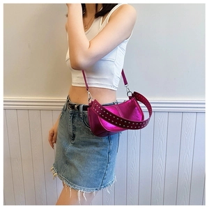 Close-up of metallic pink underarm bag featuring silver rivets and zipper detail