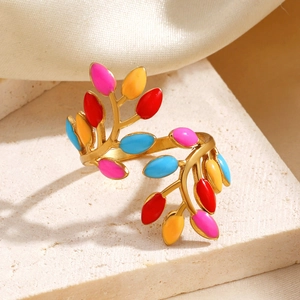 Colorful enamel leaf open ring in gold finish on natural stone and silk backdrop