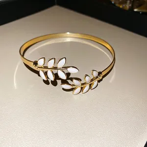 Elegant gold-tone leaf cuff bangle with white pearl enamel inlay in a minimalist design