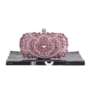 Detail of pink evening clutch bag featuring intricate pearl and crystal floral patterns
