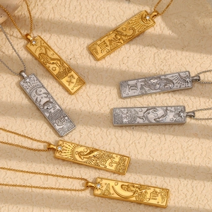 Detail of vintage square 18K gold zodiac pendants with embossed patterns and small crystal