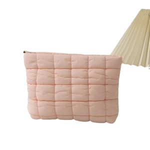 Pink quilted puffer clutch bag with square stitching and top zipper on white background