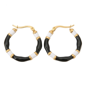 Detail of bohemian bamboo-style hoop earrings with black and white enamel finish