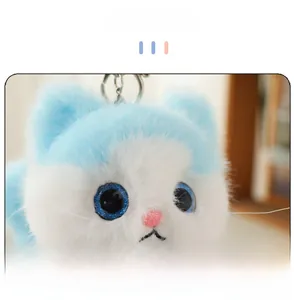 Close-up of cute plush cat keychain with blue eyes and high-quality faux fur texture