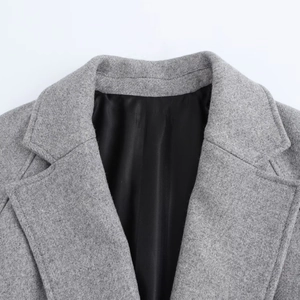 Close-up of grey wool coat featuring notched lapels and premium twill fabric texture