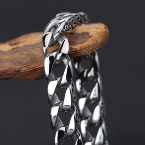 Macro shot of vintage engraved cuban link bracelet with silver finish on rustic wood
