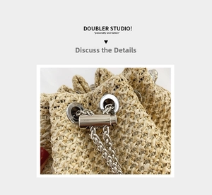 Detail of natural straw woven bucket bag featuring silver metal eyelets and chain drawstring
