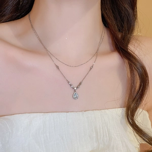 Detailed close-up of double-layer necklace featuring a blue water drop pendant with crystals