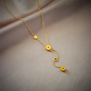Golden Y-shape necklace with circular pendants on soft silk background