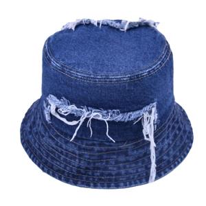 Close-up of distressed frayed edges and fringe details on dark blue denim bucket hat
