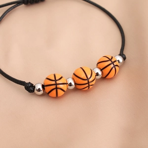 Macro di un braccialetto in cordino cerato nero regolabile con tre perle da basket