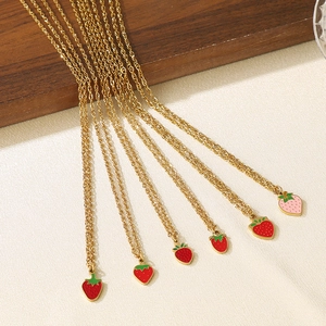 Detail of gold titanium steel necklaces with red and pink enamel strawberry pendants