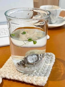 Close-up of silver steel watch submerged in water showing waterproof performance