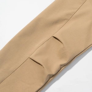 Close-up of khaki trench coat fabric showing precise stitching and textured belt design