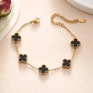 Close-up of black clover charms on gold stainless steel chain with S.STEEL hallmark