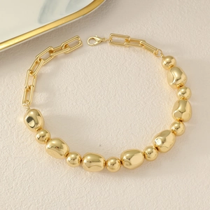 Detail of chunky gold beads and minimalist rectangular chain links with lobster clasp