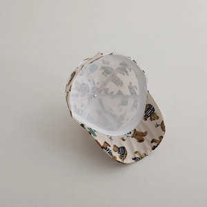 Detail of baby baseball cap with bear print showing breathable mesh lining and soft fabric