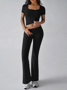 Detail view of black Y2K two-piece set featuring square neck crop top and flared trousers