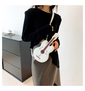 Detailed close-up of a stylish white guitar-shaped crossbody bag with strings detail