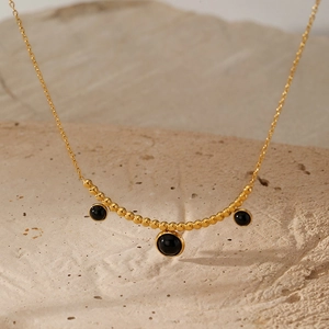 Macro di collana in acciaio inossidabile dorato con ciondoli tondi in pietra nera