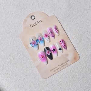 Detailed set of floral press-on nails with cherry blossom and gradient blue shell patterns