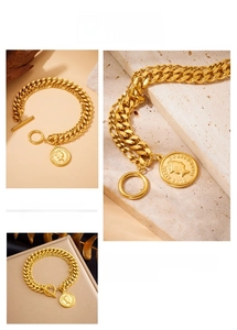 Detailed close-up of double-layer gold chain bracelet with OT clasp and coin pendant