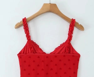 Détail de la robe rouge à imprimé cœur avec col en V et bretelles à volants