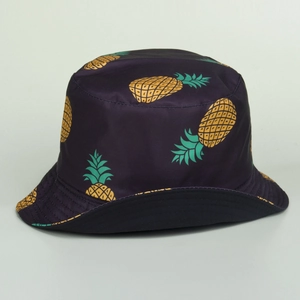 Detail of a dark purple bucket hat with vibrant yellow pineapple print for beach sun protection