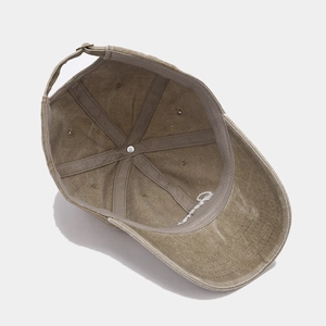 Detail of khaki washed cotton baseball cap inner structure and white letter embroidery