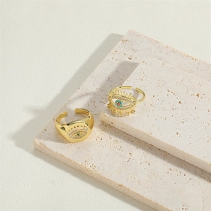 Vintage gold evil eye ring set with zircon stones on natural stone pedestal