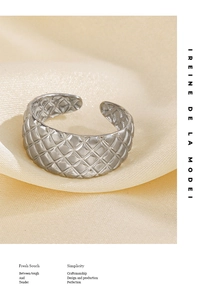 Detailansicht des silbernen verstellbaren Rings mit gesteppter Textur auf gelber Seide