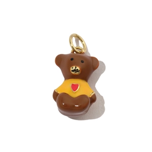 Detail of cartoon bear pendant with brown fur yellow shirt and red heart charm