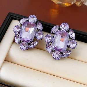Gros plan de boucles d'oreilles vintage en cristal violet dans un écrin de luxe