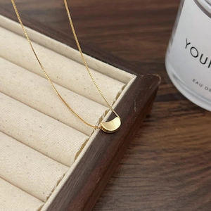 Minimalist 925 sterling silver gold crescent moon necklace on elegant wooden display