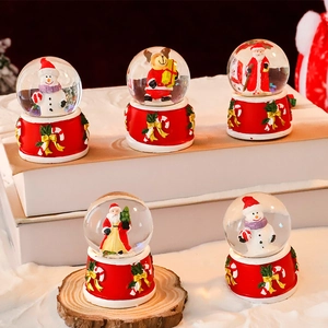 Mini Christmas snow globes with Santa and reindeer on festive red bases for holiday decor